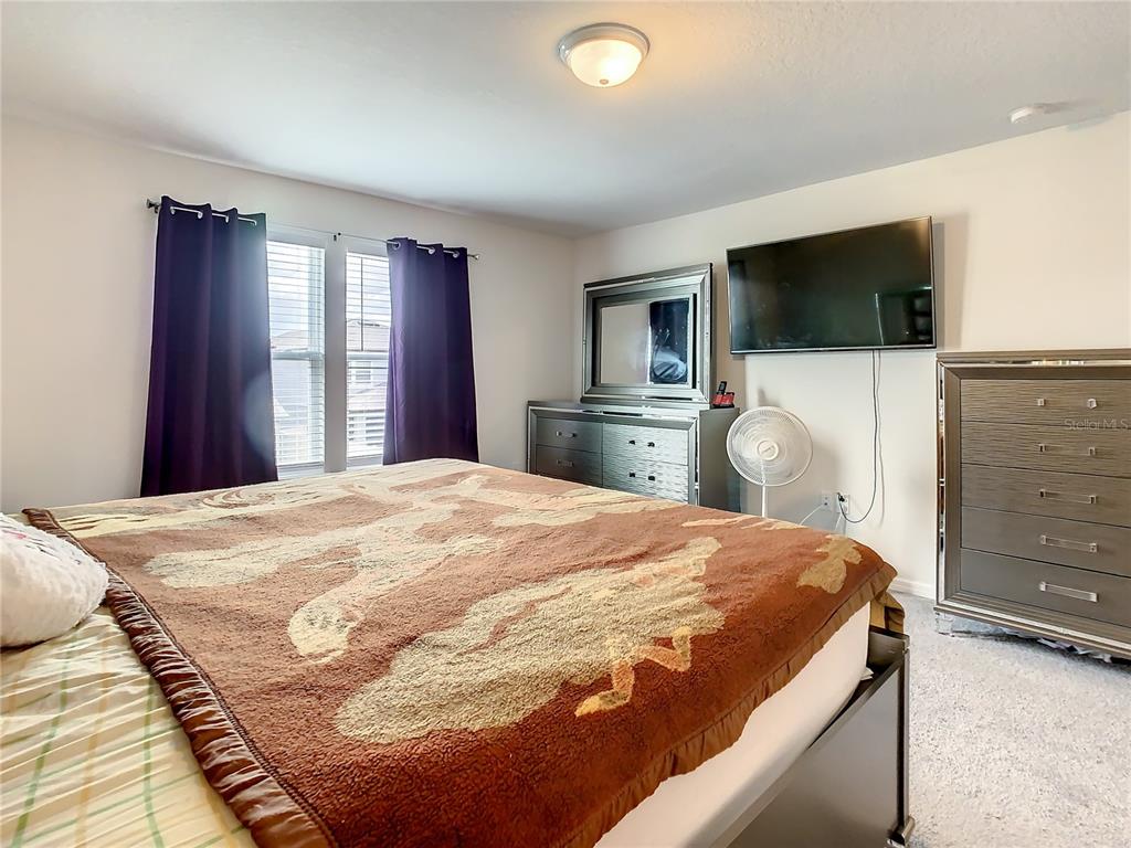 30344 Marquette Avenue Wesley Chapel, FL 33545 - Photo 41 of 71 a bedroom with a bed and a flat screen tv