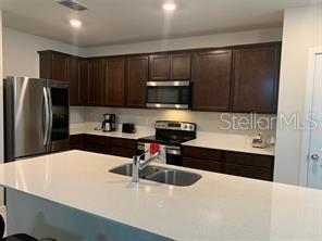30344 Marquette Avenue Wesley Chapel, FL 33545 - Photo 60 of 71 a kitchen with kitchen island a sink stainless steel appliances and cabinets