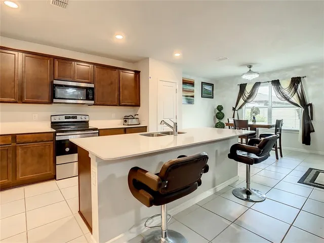 a kitchen with stainless steel appliances a sink a stove a refrigerator and cabinets