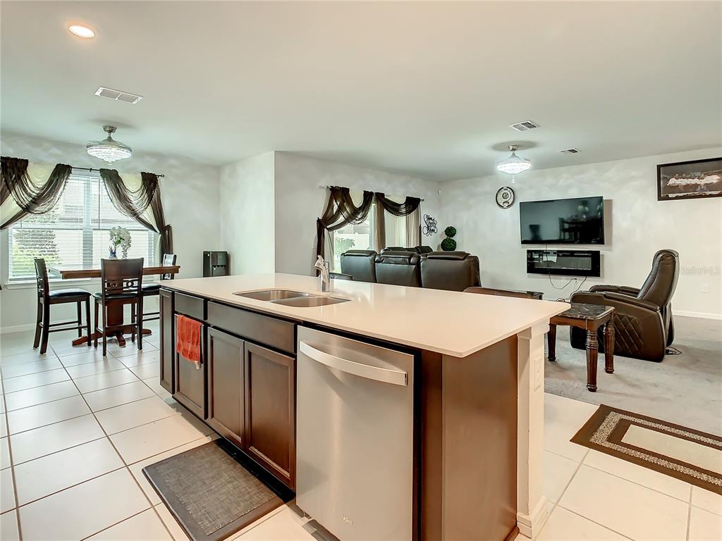 30344 Marquette Avenue Wesley Chapel, FL 33545 - Photo 8 of 71 a kitchen with stainless steel appliances kitchen island granite countertop a sink and a refrigerator