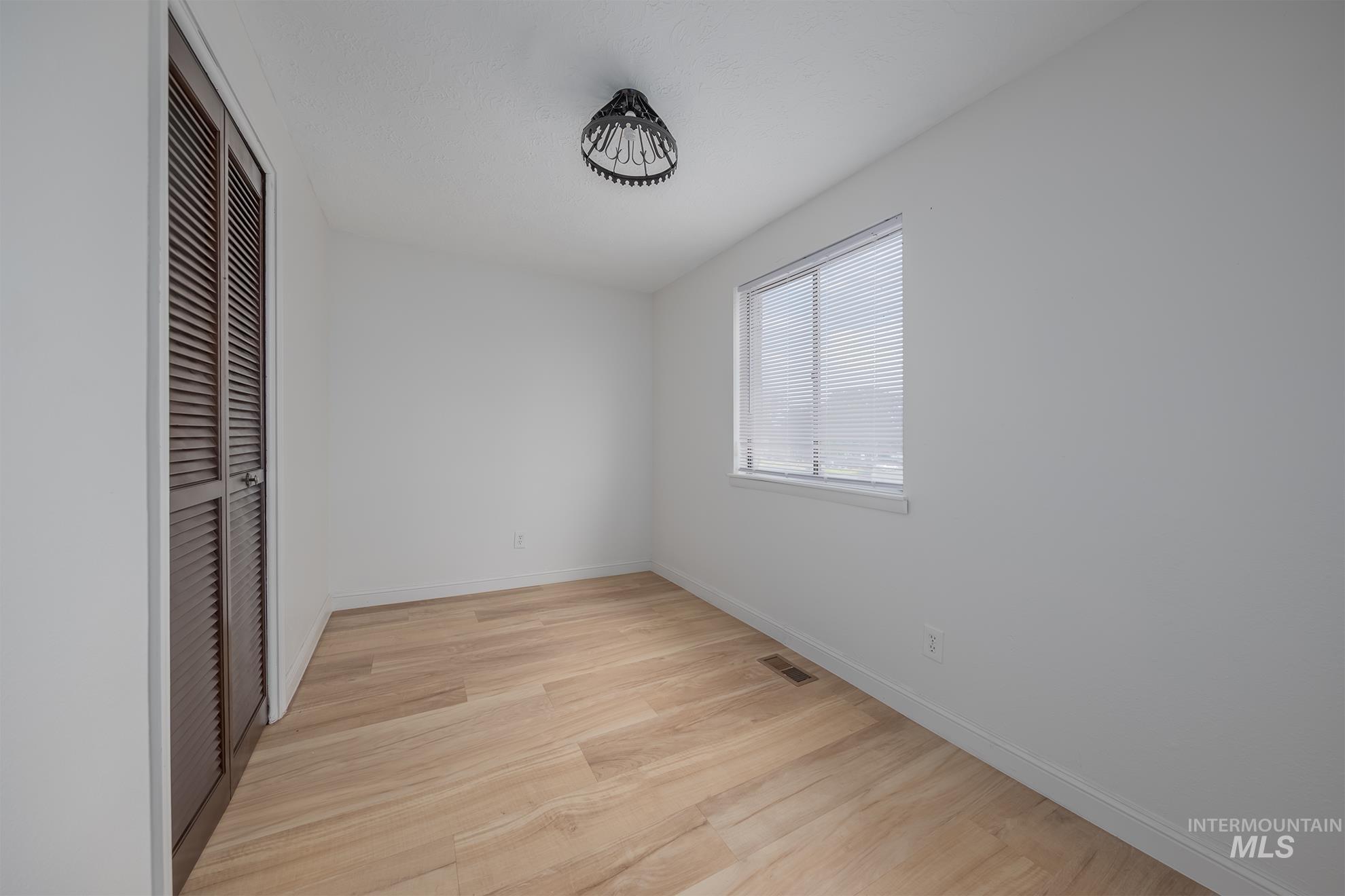 61 Southwest 4th Street Ontario, OR 97914 - Photo 22 of 42 Room featuring light wood-finish flooring, white walls, and a window with blinds