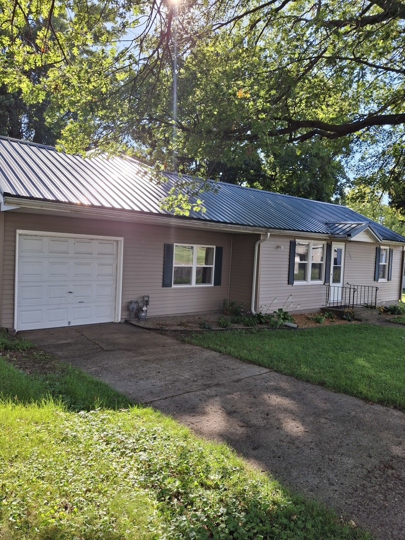 304 Depot Street Walnut, IL 61376 - Photo 1 of 12 a view of a yard in front of a house with large trees