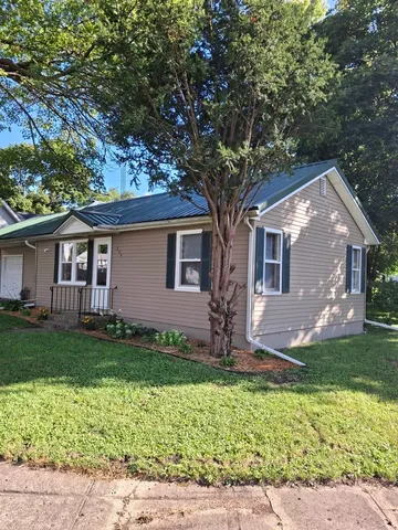 a front view of a house with a garden