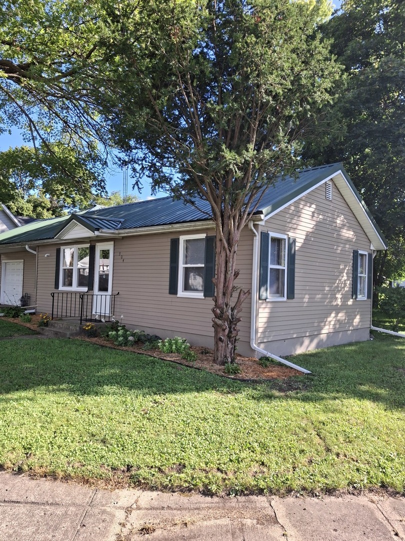 304 Depot Street Walnut, IL 61376 - Photo 2 of 12 a front view of a house with a garden
