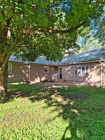a view of backyard with table and chairs and a large tree