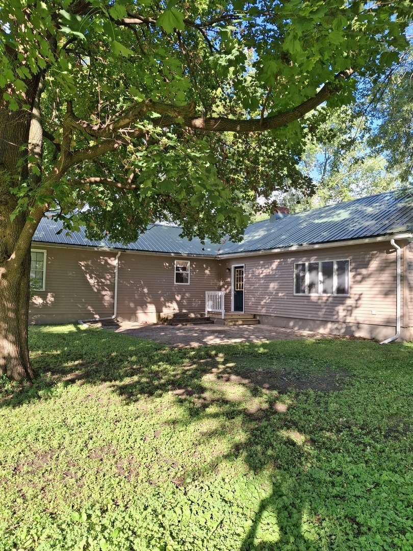 304 Depot Street Walnut, IL 61376 - Photo 3 of 12 a view of backyard with table and chairs and a large tree
