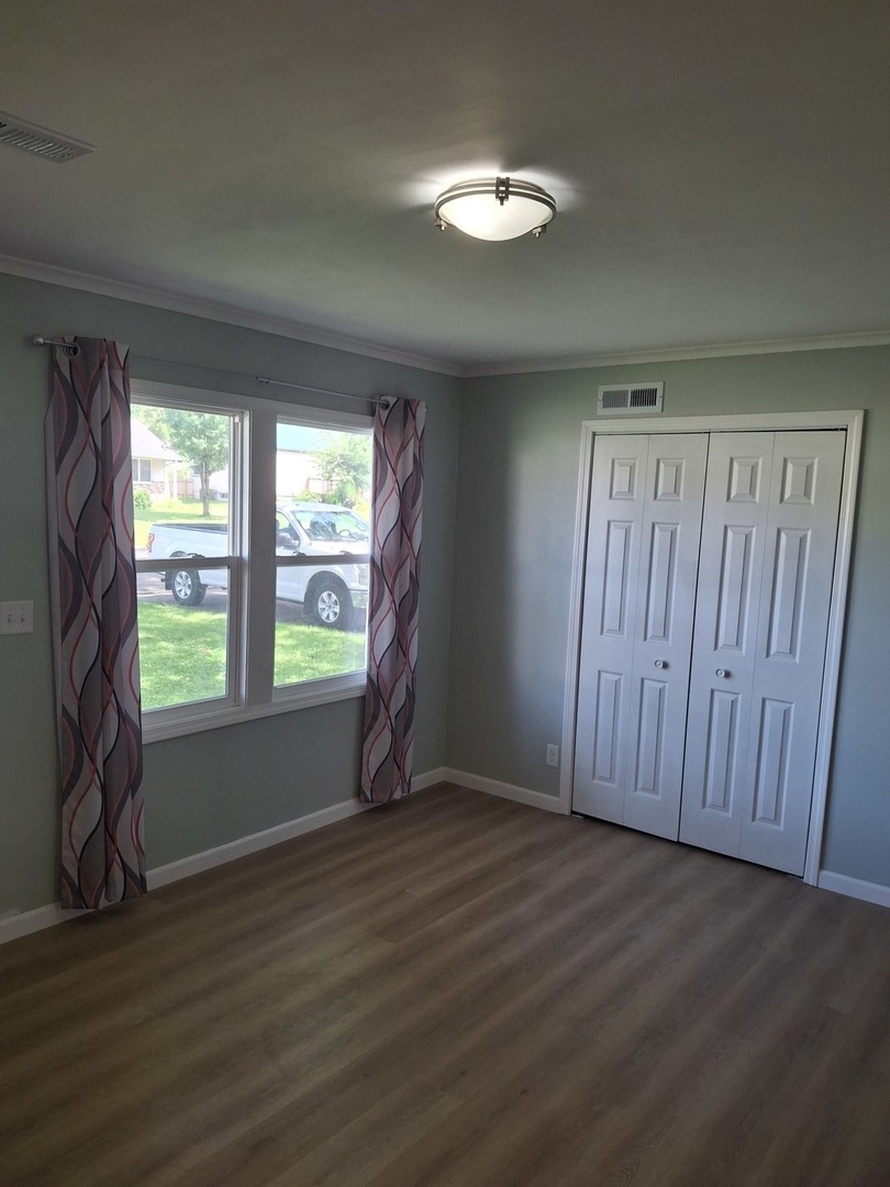 304 Depot Street Walnut, IL 61376 - Photo 6 of 12 an empty room with wooden floor and windows