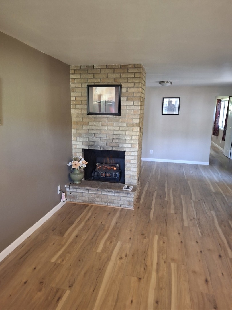 304 Depot Street Walnut, IL 61376 - Photo 8 of 12 a view of empty room with wooden floor and fireplace
