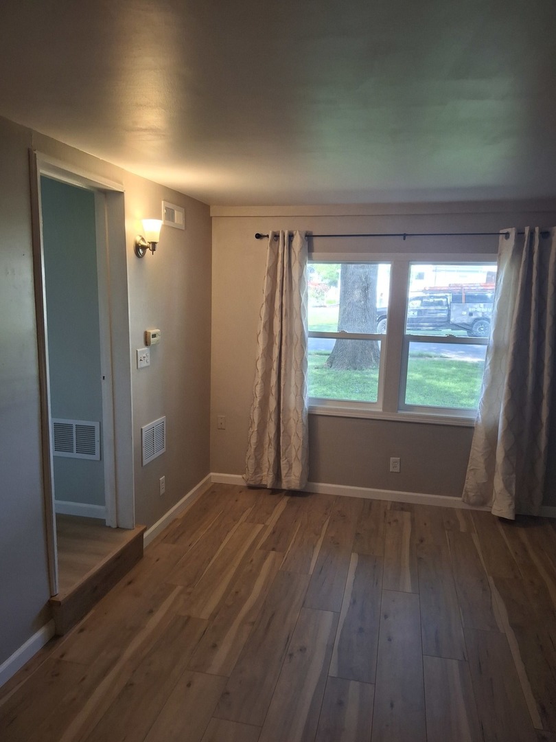 304 Depot Street Walnut, IL 61376 - Photo 10 of 12 an empty room with wooden floor and windows