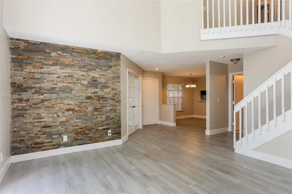 en empty room with wooden floor and brick wall
