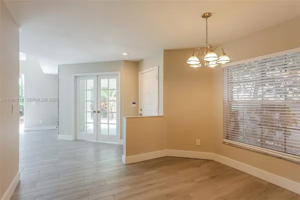 a view of a livingroom with a chandelier wooden floor and a chandelier