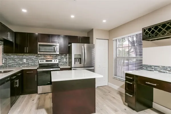 a kitchen with stainless steel appliances granite countertop a stove refrigerator sink and microwave