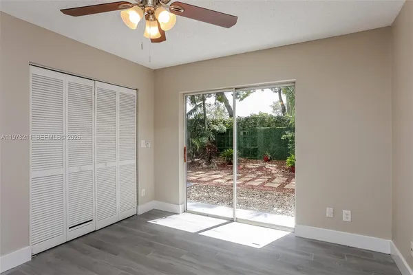 an empty room with wooden floor and balcony