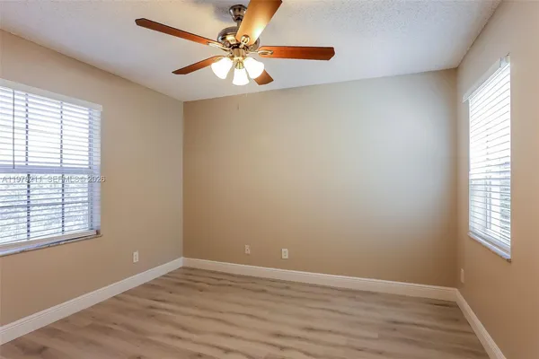 an empty room with a window and a fan