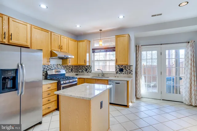 a kitchen with a sink a counter top space stainless steel appliances and cabinets