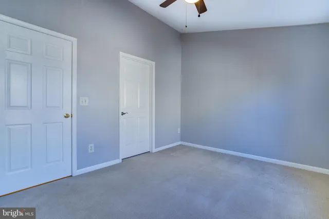 an empty room with closet and a bathroom