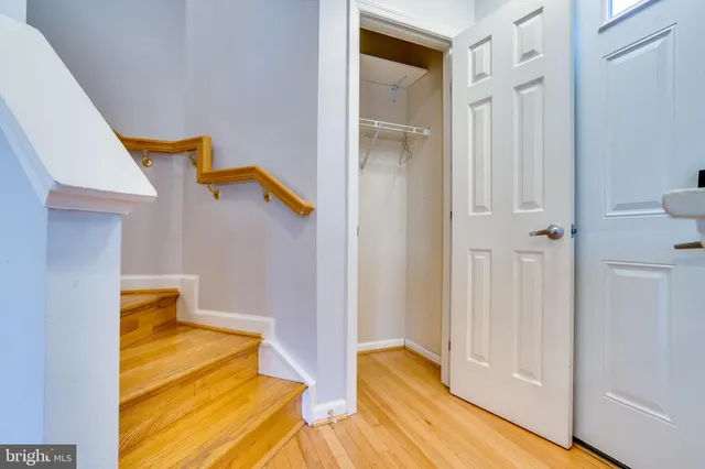 a view of an empty room with wooden floor and entryway