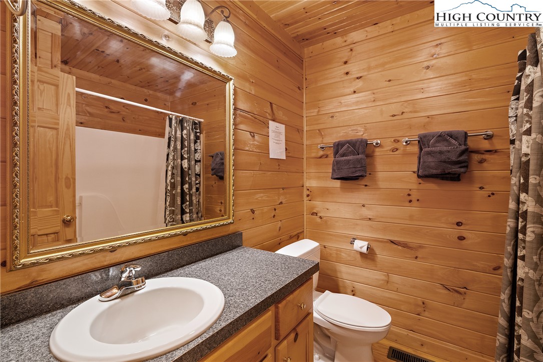 2935 Buck Mountain Road Purlear, NC 28665 - Photo 21 of 49 a bathroom with a granite countertop toilet sink and mirror
