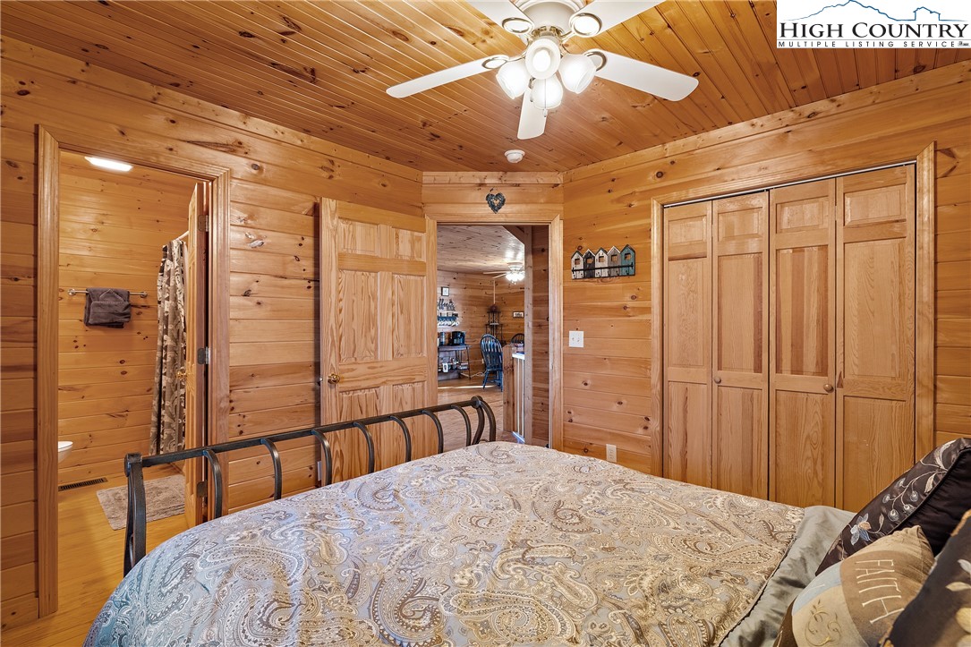 2935 Buck Mountain Road Purlear, NC 28665 - Photo 22 of 49 a bedroom with a bed and a chandelier