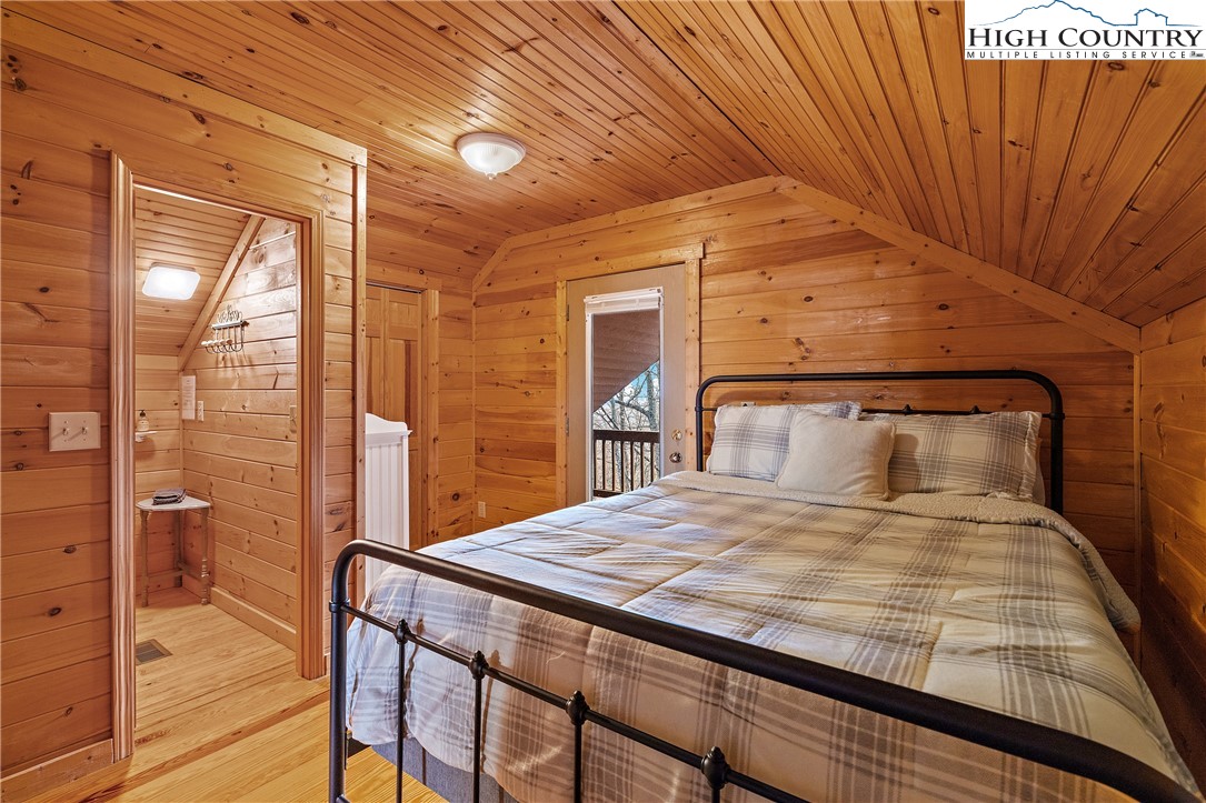 2935 Buck Mountain Road Purlear, NC 28665 - Photo 33 of 49 a bedroom with a bed and wooden floor
