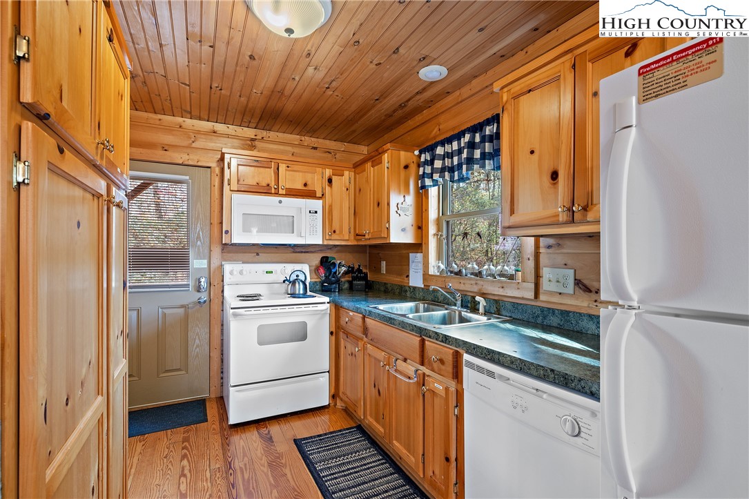 2935 Buck Mountain Road Purlear, NC 28665 - Photo 7 of 49 a kitchen with stainless steel appliances granite countertop a refrigerator a sink dishwasher a stove and white countertops with wooden floor