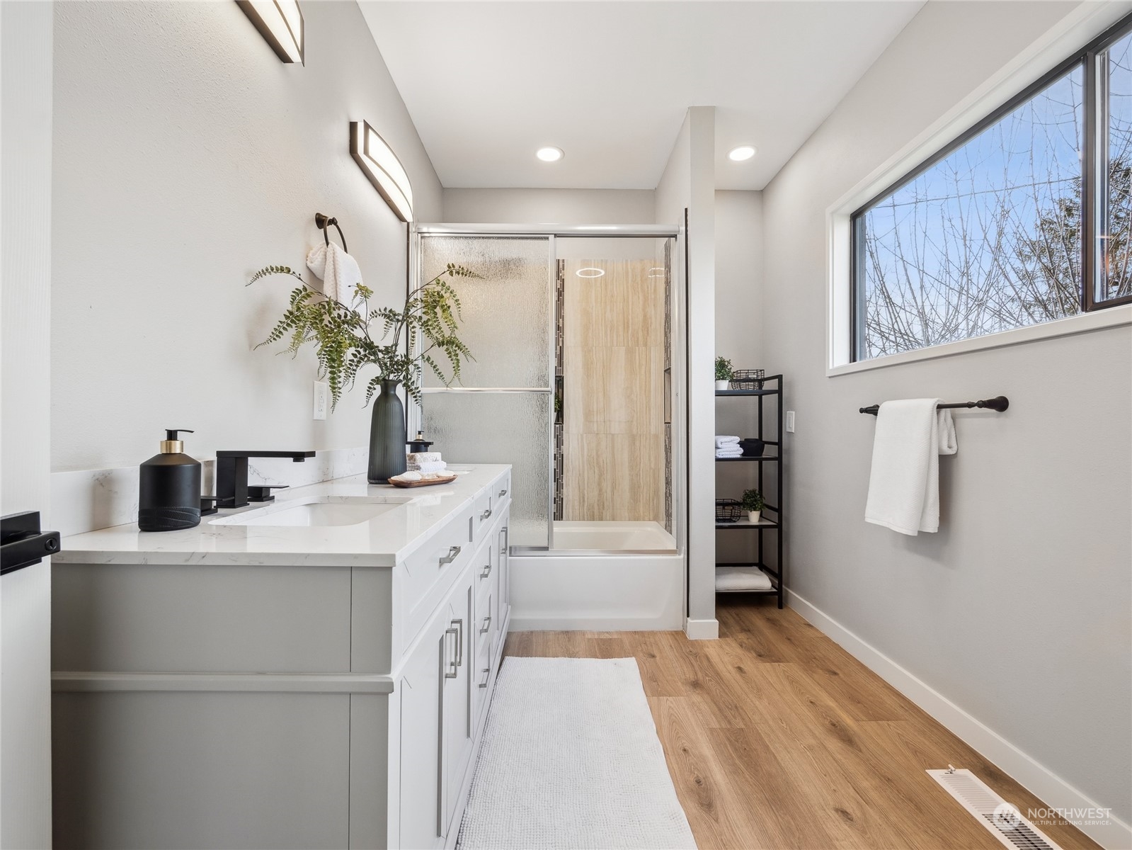 1502 16th Street Sumner, WA 98390 - Photo 15 of 26 a bathroom with a sink a large mirror and a shower