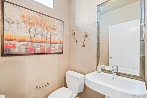 a bathroom with a toilet a sink and a mirror