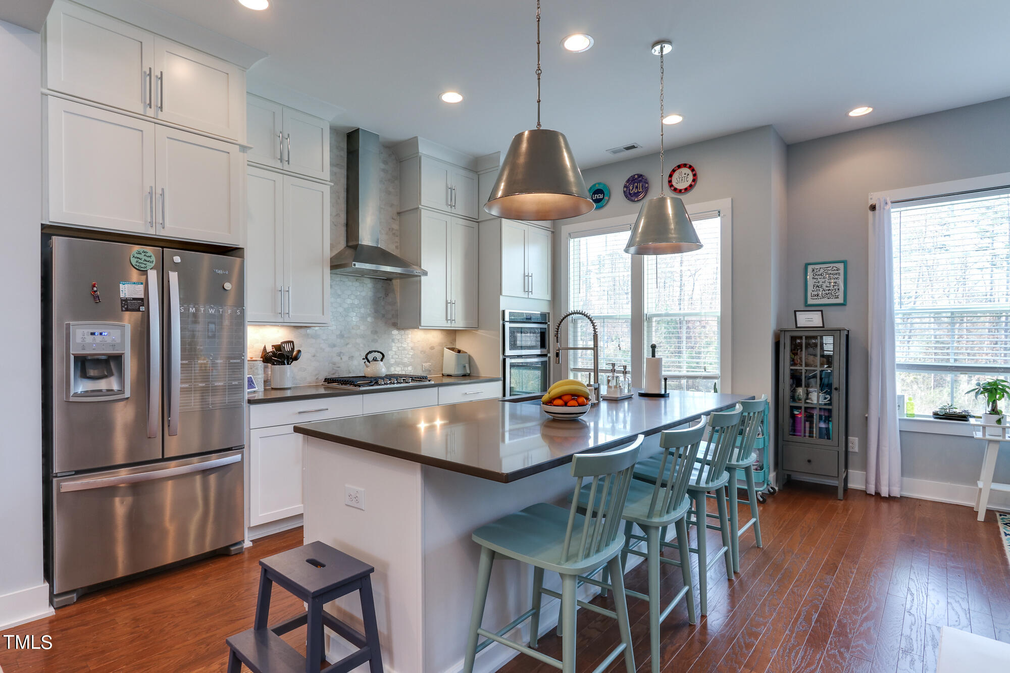904 Wake Towne Drive Raleigh, NC 27609 - Photo 1 of 30 a kitchen with stainless steel appliances a table chairs wooden floors and a large window
