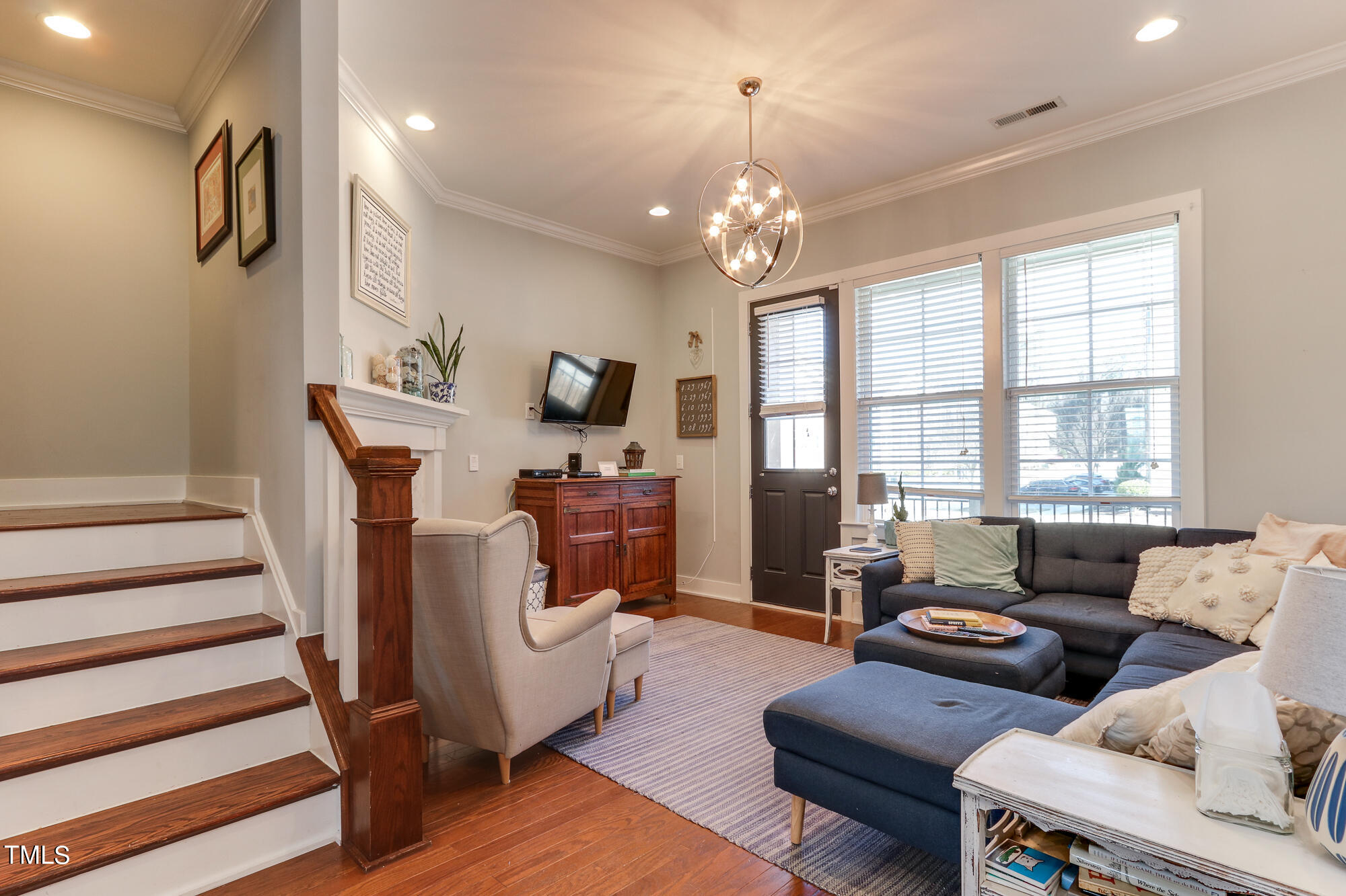 904 Wake Towne Drive Raleigh, NC 27609 - Photo 5 of 30 a living room with furniture a fireplace and a chandelier