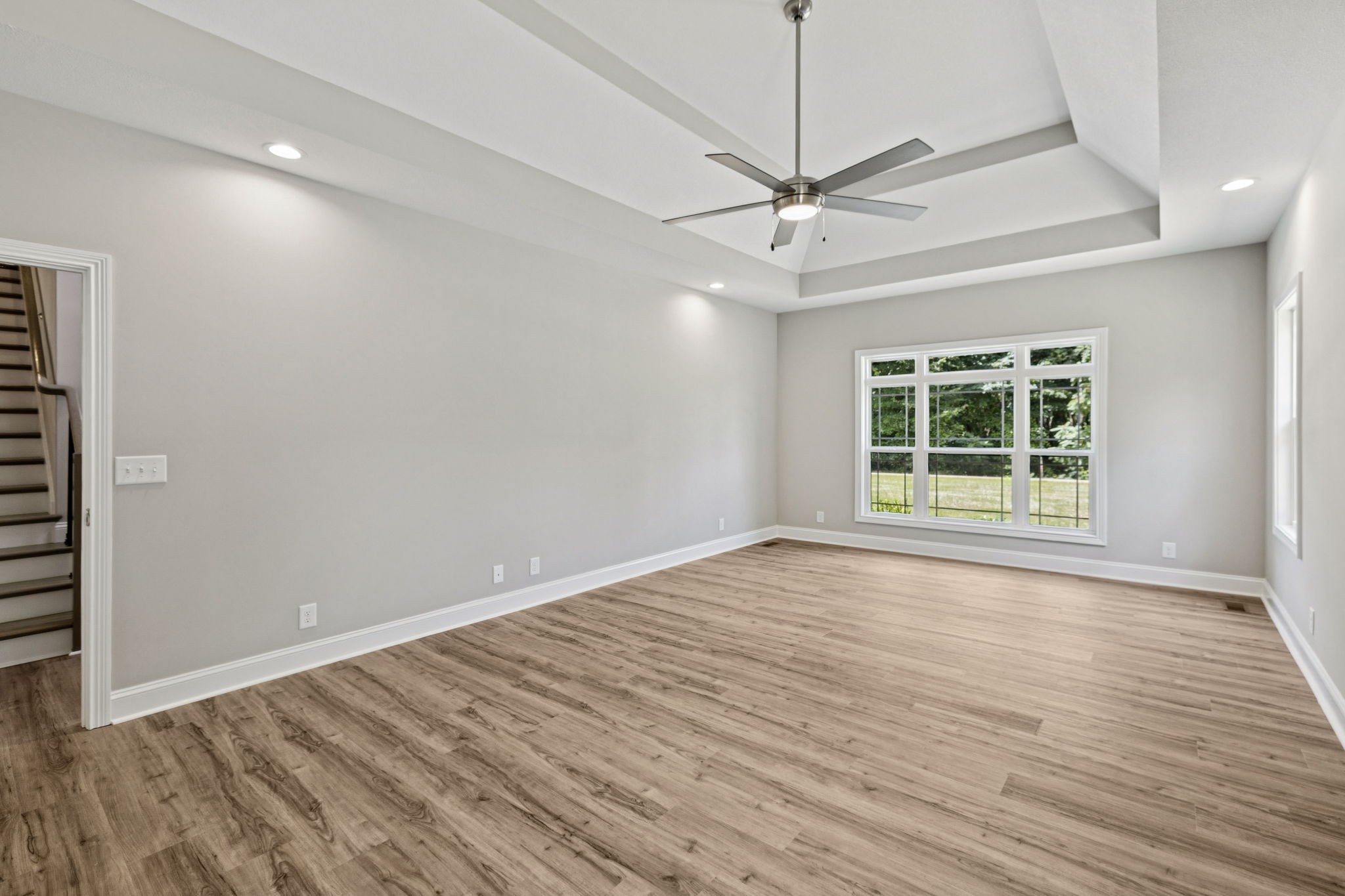 1017 Gholson Road Clarksville, TN 37043 - Photo 19 of 58 an empty room with wooden floor chandelier fan and windows