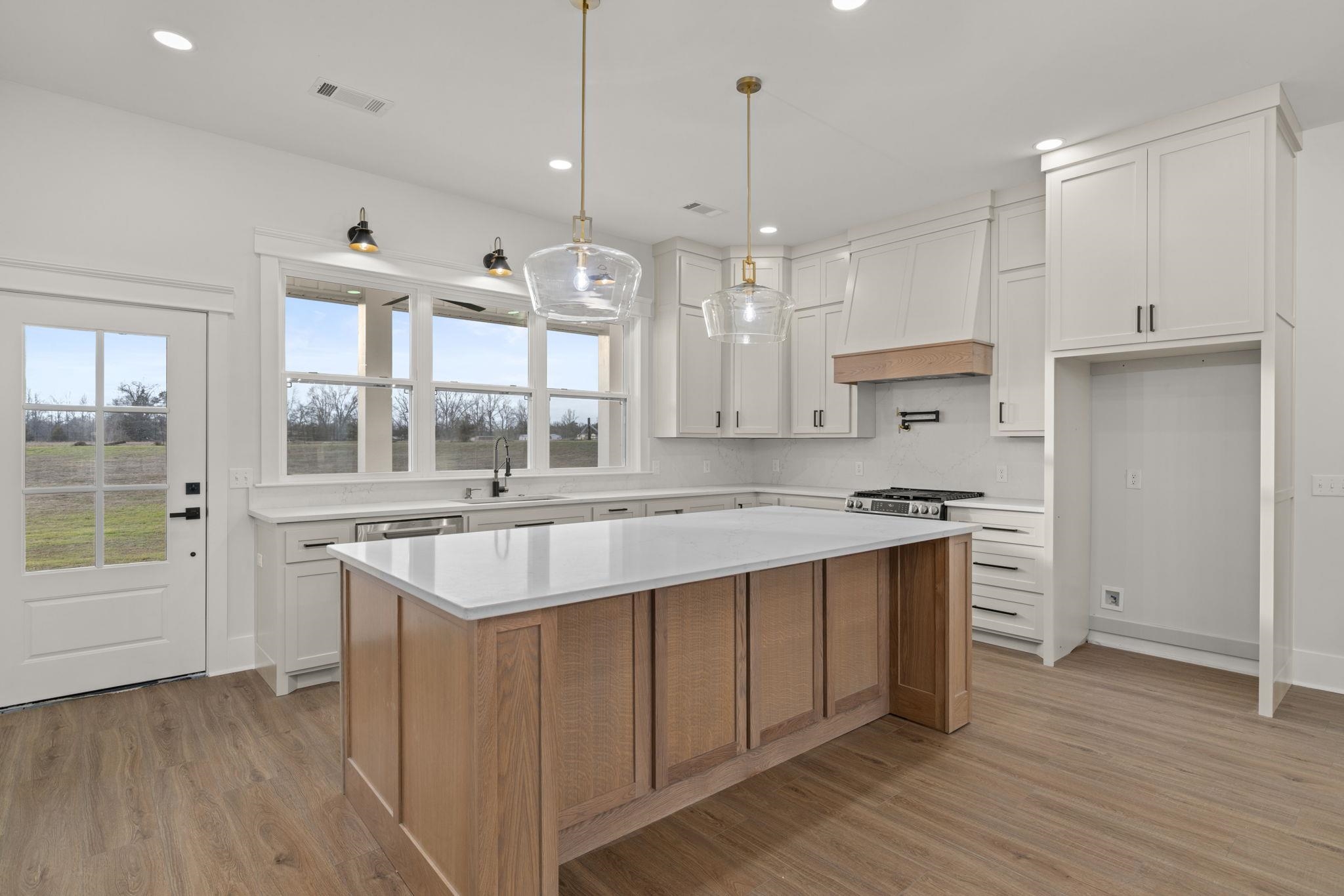 69 County Road 157 Corinth, MS 38834 - Photo 11 of 39 a large kitchen with kitchen island a stove a sink a center island and wooden floor