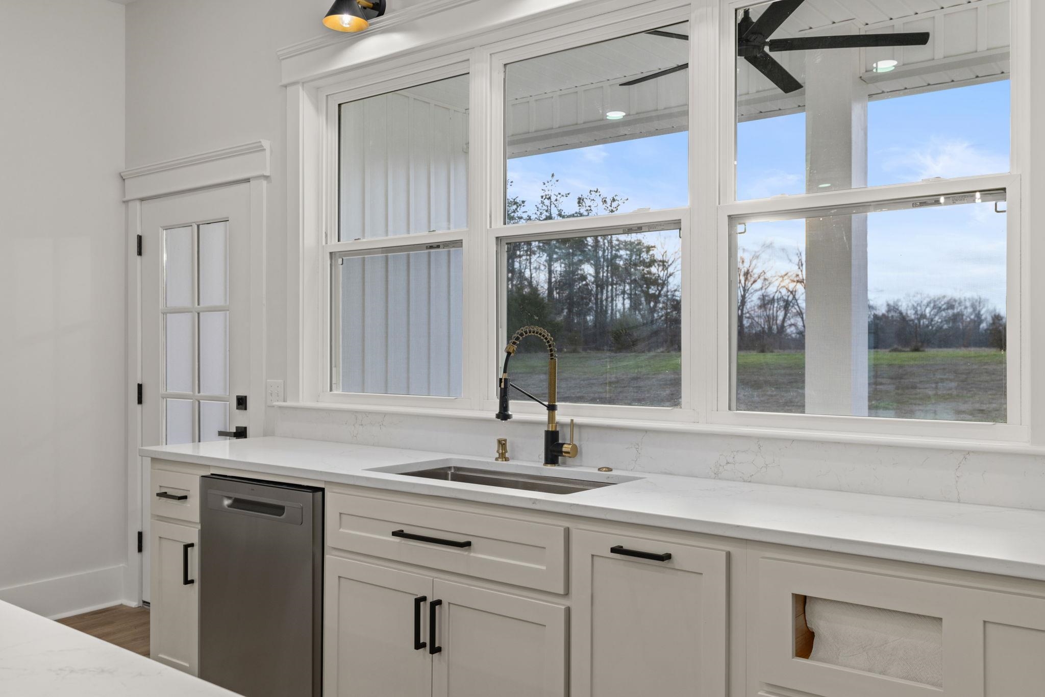 69 County Road 157 Corinth, MS 38834 - Photo 15 of 39 Kitchen featuring white cabinets, light stone counters, stainless steel dishwasher, and healthy amount of natural light