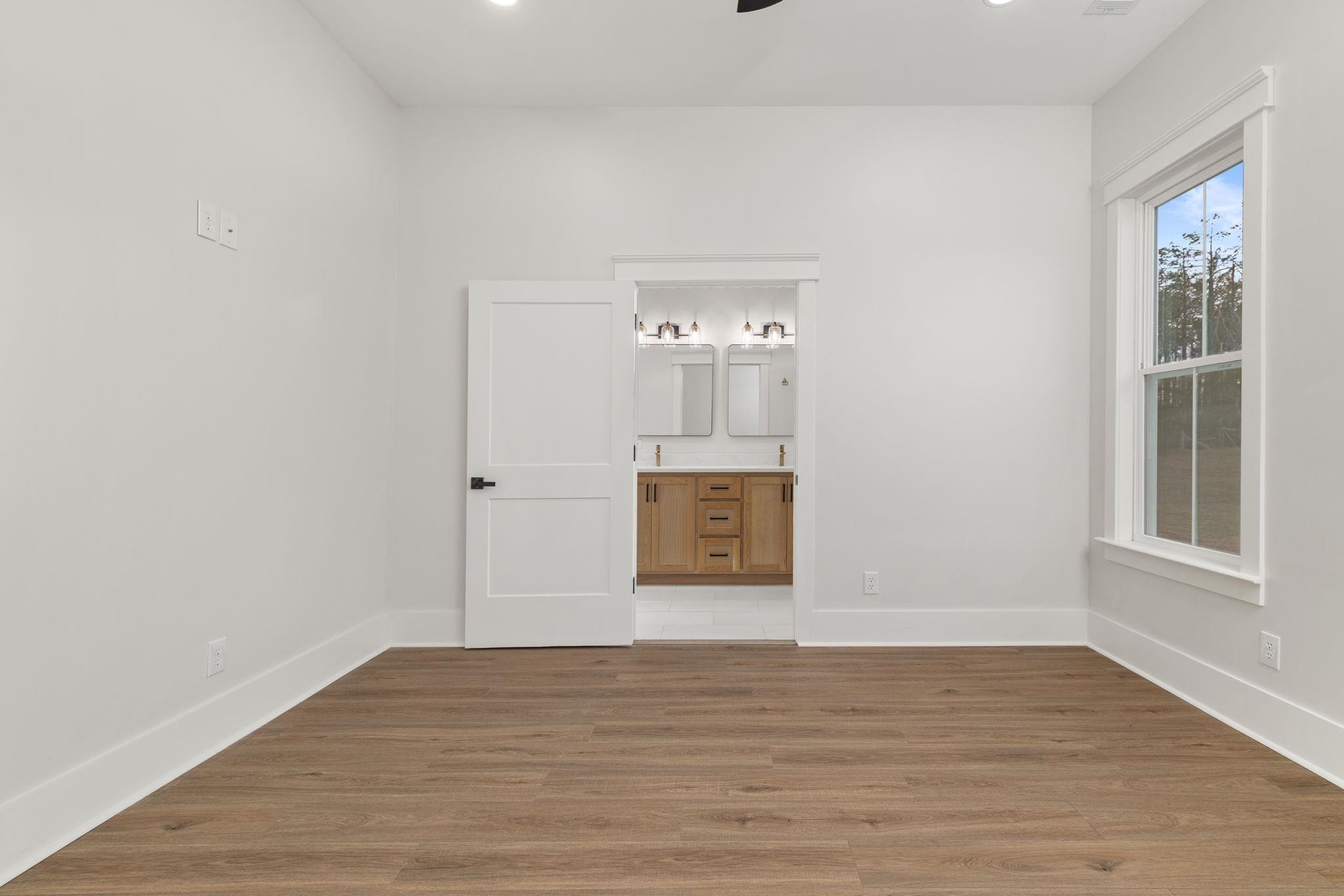 69 County Road 157 Corinth, MS 38834 - Photo 17 of 39 Unfurnished bedroom with light wood finished floors, ensuite bathroom, recessed lighting, and a ceiling fan