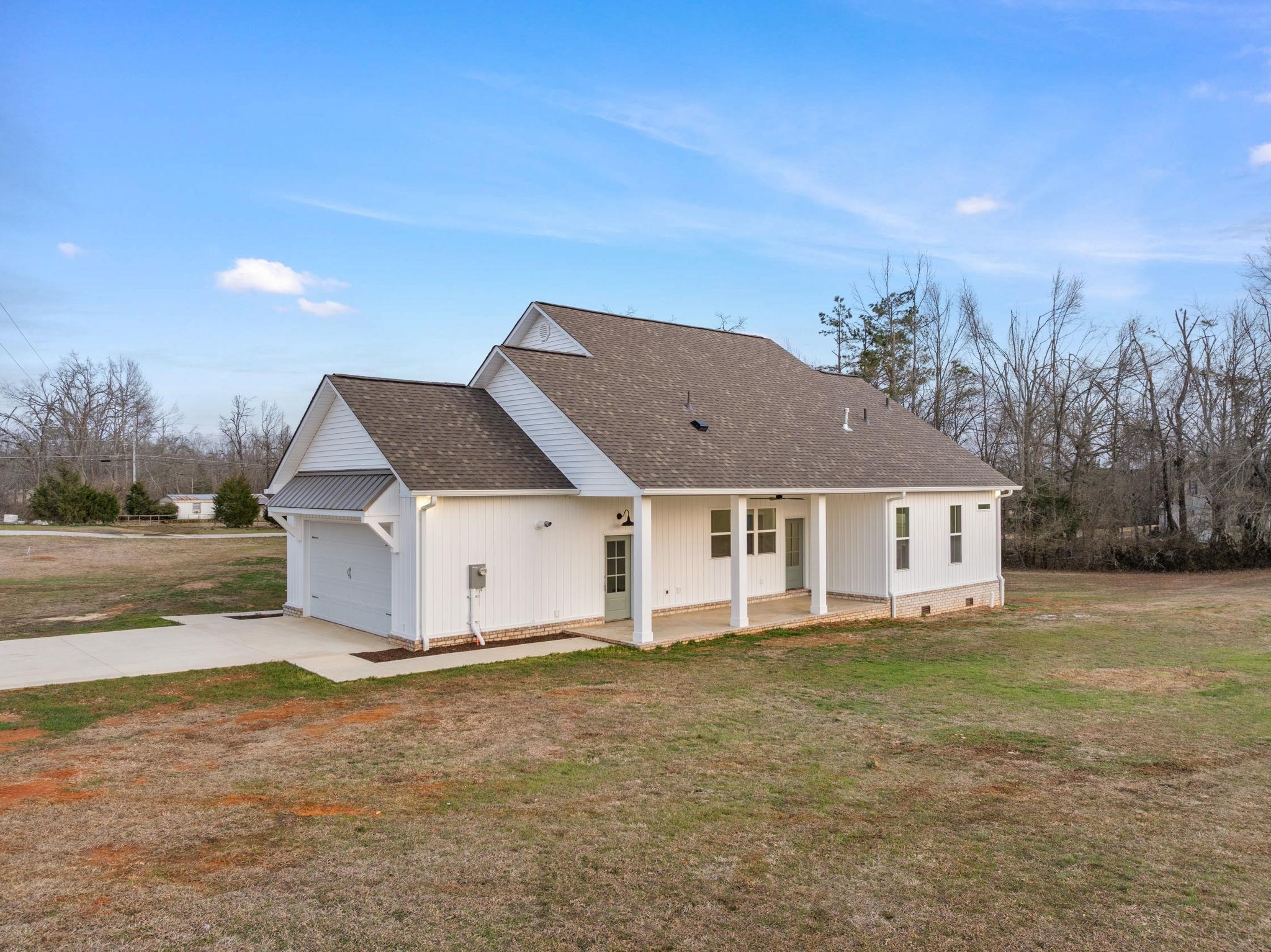 69 County Road 157 Corinth, MS 38834 - Photo 31 of 39 Rear view of house featuring a shingled roof, driveway, a garage, a yard, and crawl space