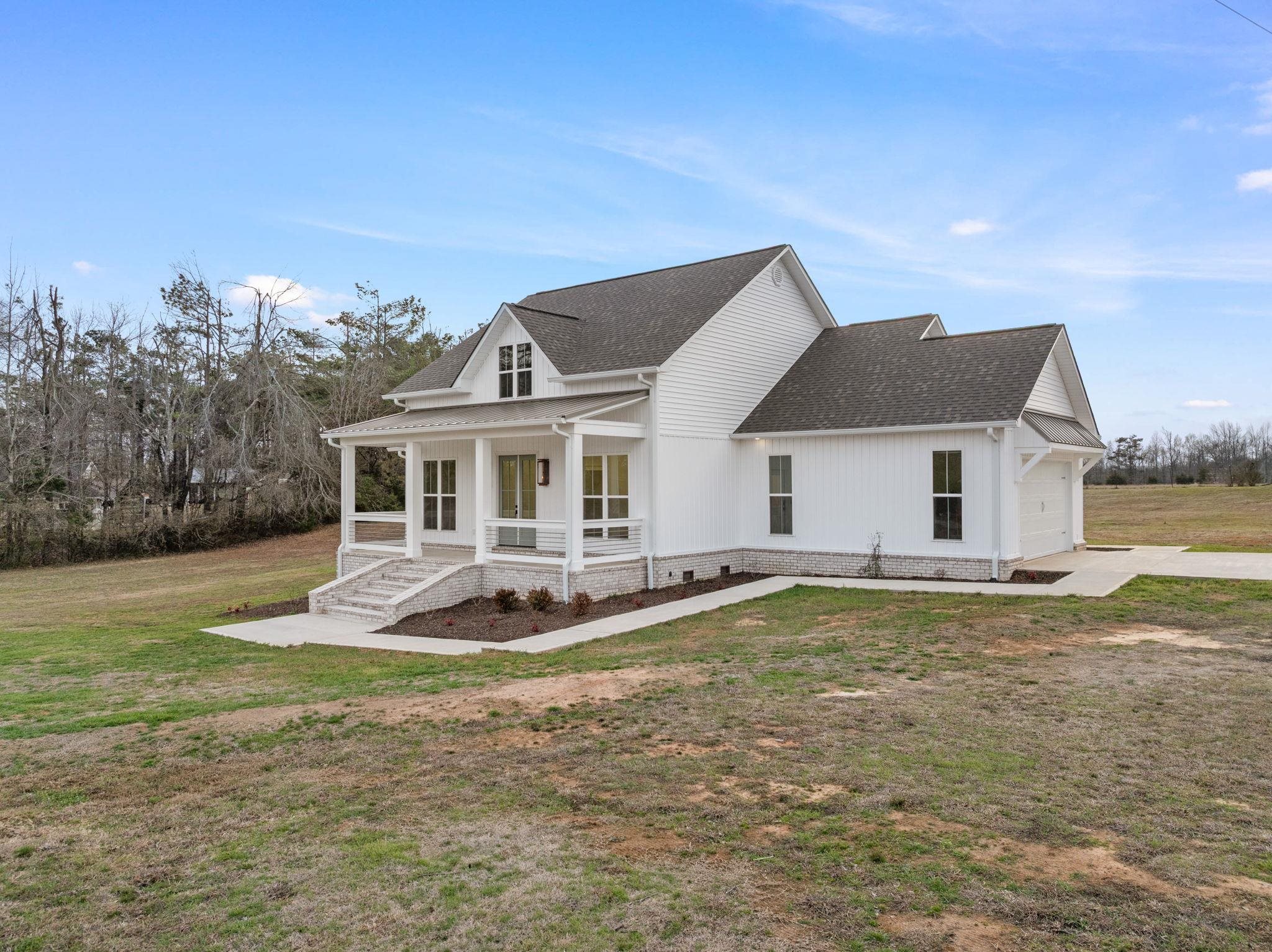 69 County Road 157 Corinth, MS 38834 - Photo 5 of 39 View of front of home featuring covered porch, a shingled roof, a front yard, a garage, and concrete driveway