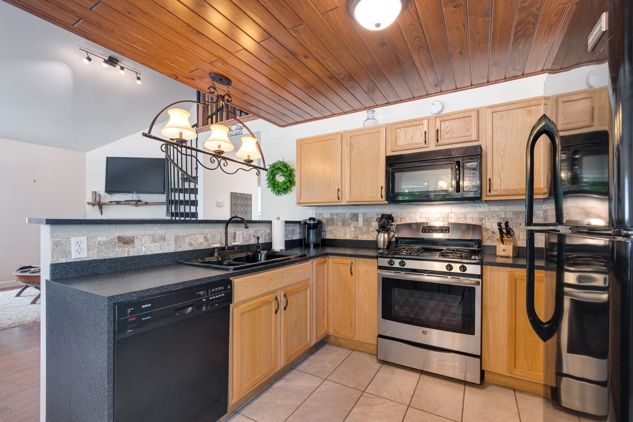 752 Pevahouse Camp Lane Decaturville, TN 38329 - Photo 15 of 47 a kitchen with stainless steel appliances granite countertop a sink a stove a microwave and cabinets