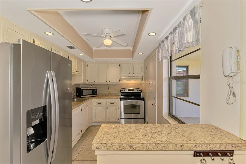 96 Boundary Boulevard, Unit 127 Rotonda West, FL 33947 - Photo 14 of 47 a kitchen with stainless steel appliances granite countertop a refrigerator and a stove top oven