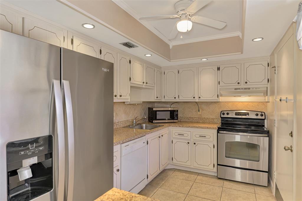 96 Boundary Boulevard, Unit 127 Rotonda West, FL 33947 - Photo 15 of 47 a kitchen with cabinets stainless steel appliances and a counter space
