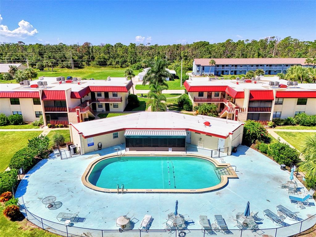 96 Boundary Boulevard, Unit 127 Rotonda West, FL 33947 - Photo 38 of 47 a small pool with lawn chairs and a fire pit