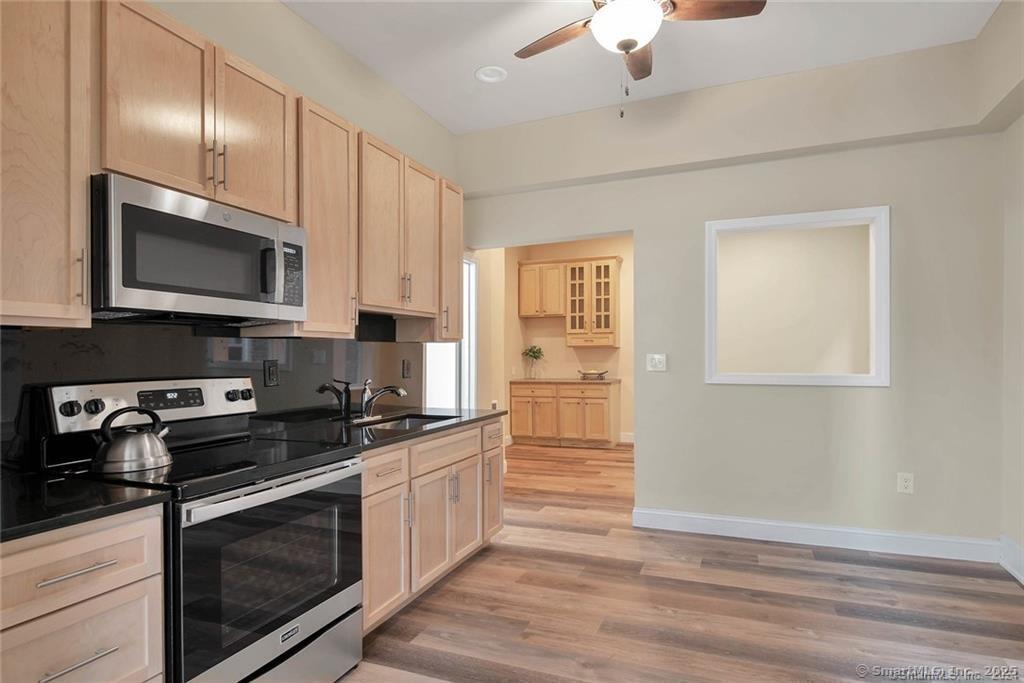 120 East Main Street, Unit 6 Torrington, CT 06790 - Photo 7 of 12 a kitchen with granite countertop cabinets stainless steel appliances and wooden floor