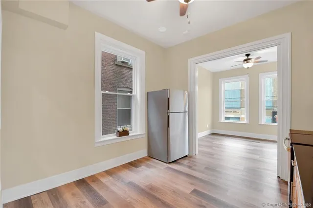 an empty room with wooden floor and windows
