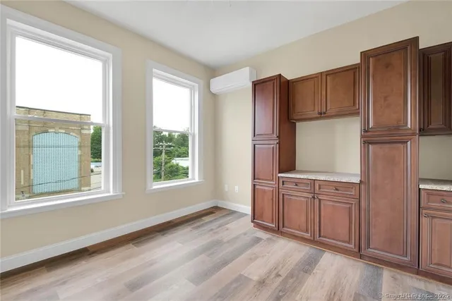 a view of a kitchen with wooden floor and electronic appliances