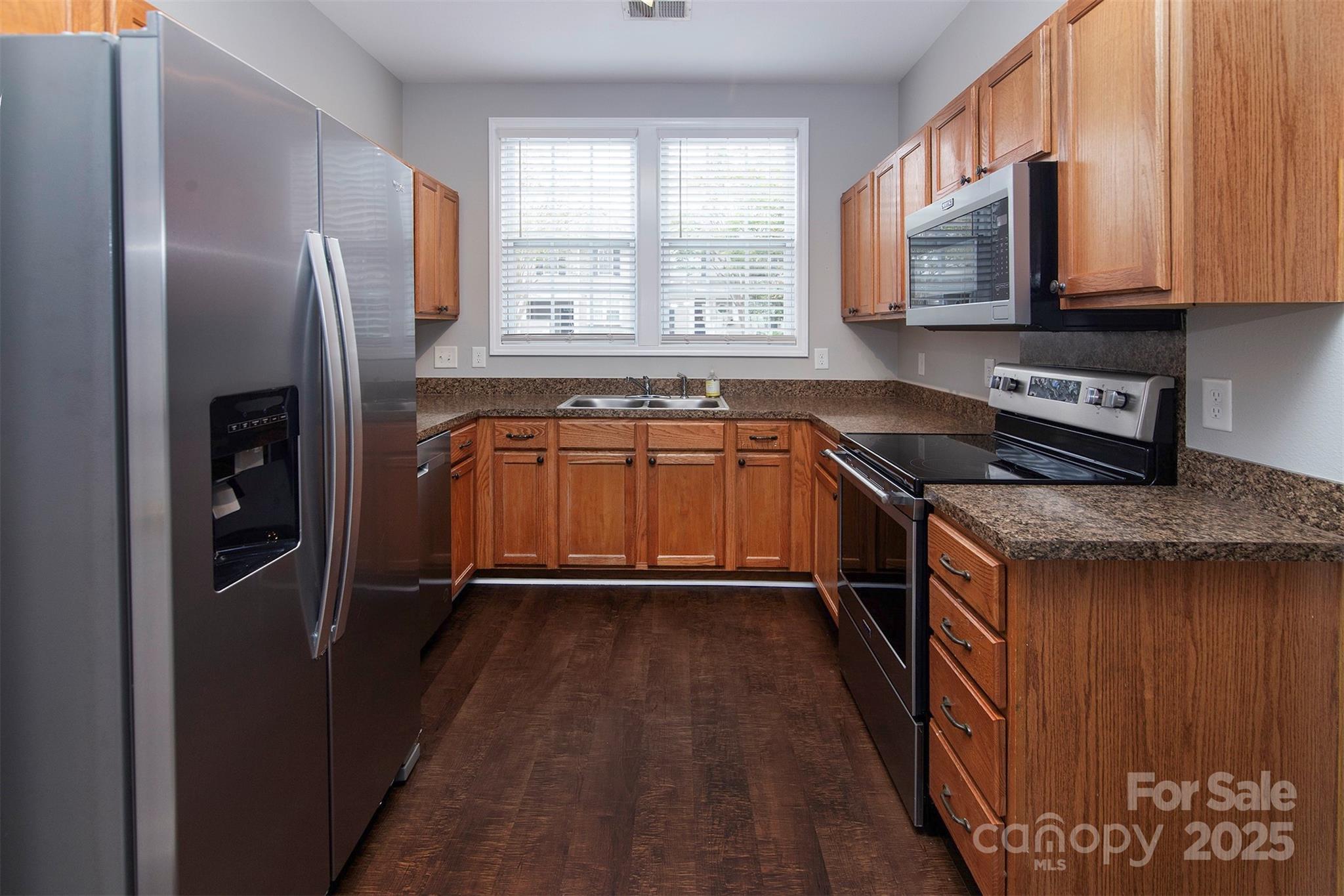 6310 Rhodins Lane Fort Mill, SC 29707 - Photo 5 of 22 a kitchen with granite countertop a refrigerator stove and sink