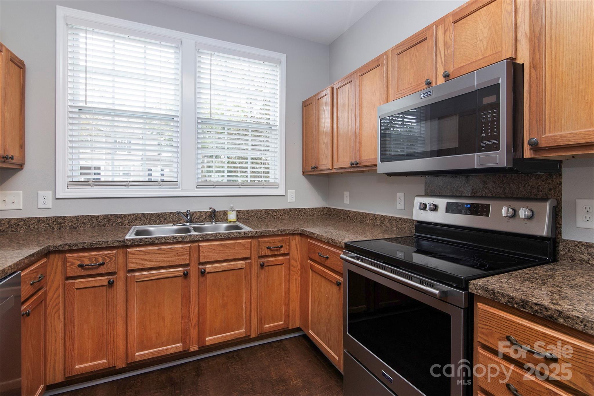 6310 Rhodins Lane Fort Mill, SC 29707 - Photo 7 of 22 a kitchen with granite countertop a stove microwave and sink