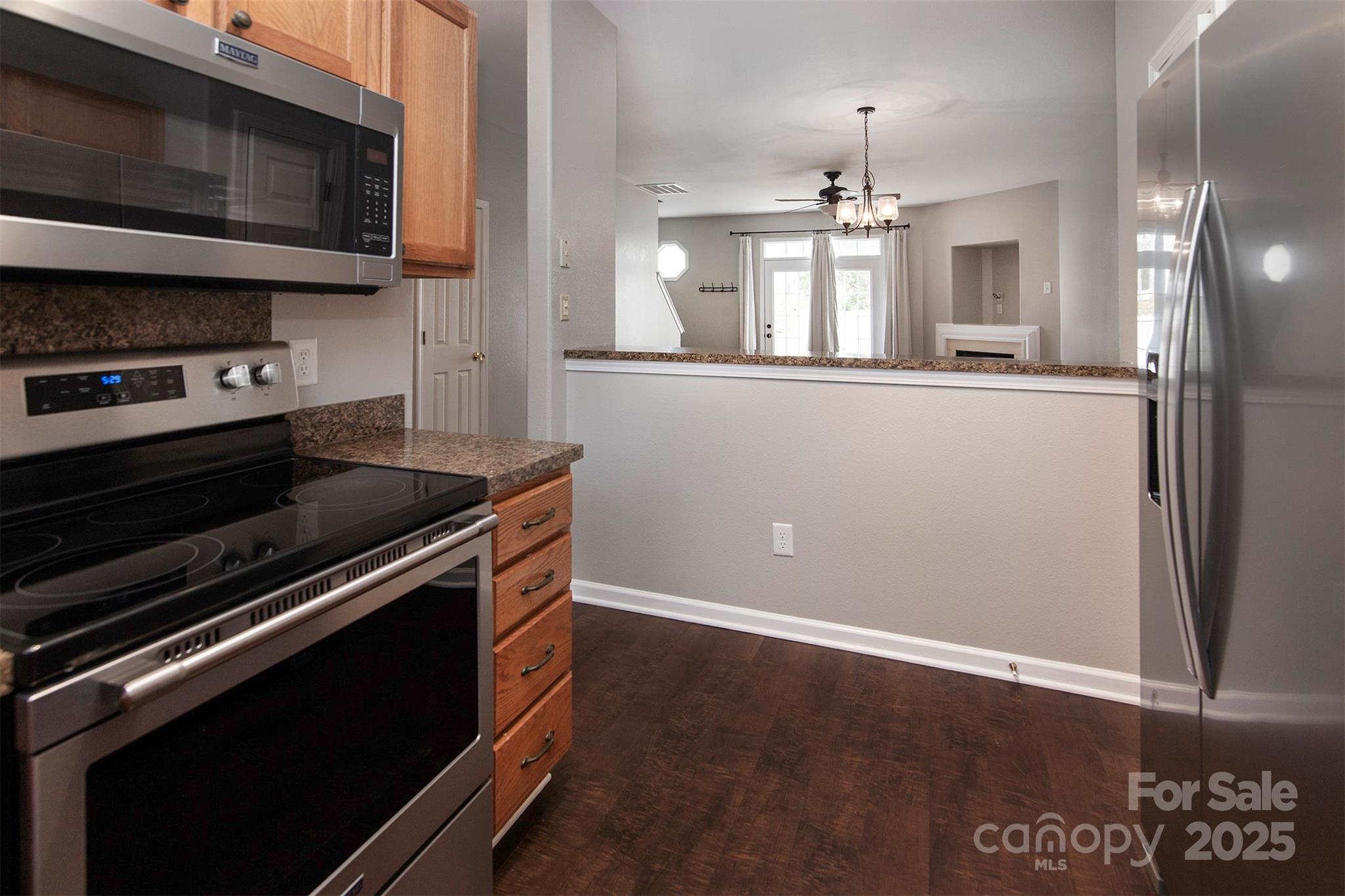 6310 Rhodins Lane Fort Mill, SC 29707 - Photo 8 of 22 a kitchen with kitchen island granite countertop stainless steel appliances and wooden cabinets