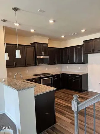 a kitchen with stainless steel appliances kitchen island granite countertop a stove and a sink