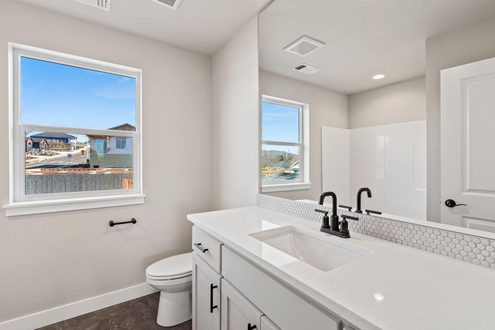 1135 Pumpkin Ridge, Unit 319 Eagle Point, OR 97524 - Photo 31 of 34 a bathroom with a sink vanity mirror and toilet