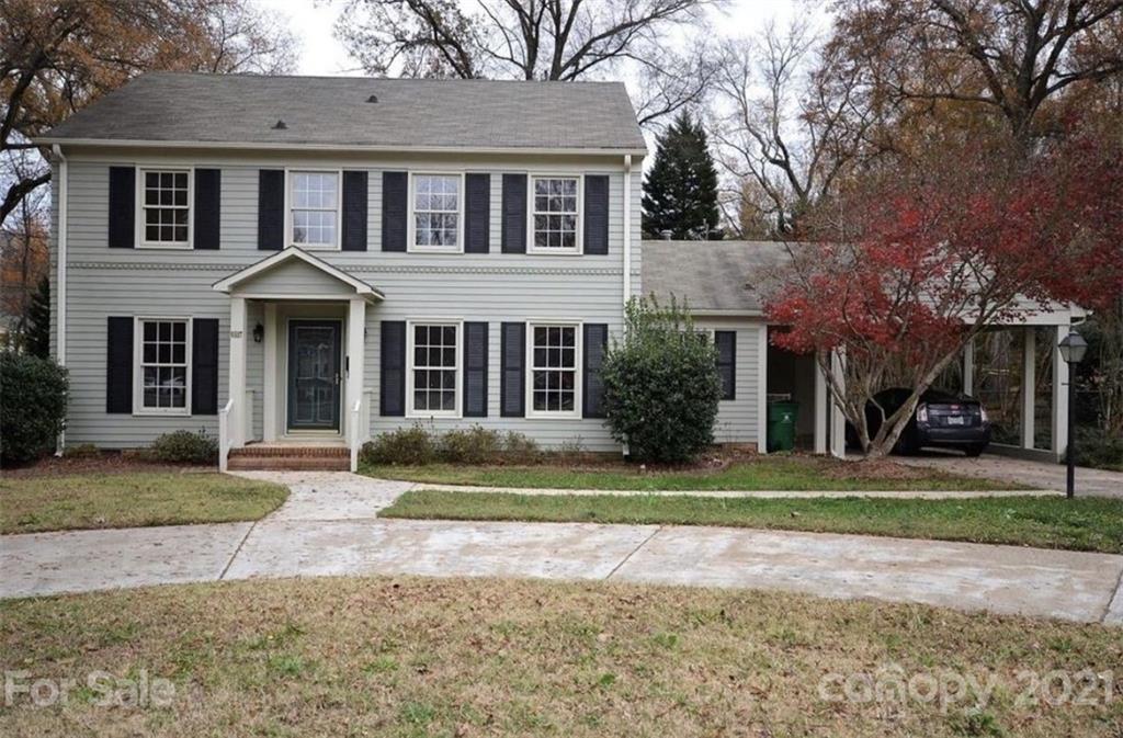 a front view of a house with a yard and trees