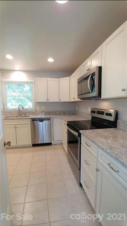 6517 Park Road Charlotte, NC 28210 - Photo 2 of 20 a kitchen with stainless steel appliances granite countertop a stove a sink and a microwave