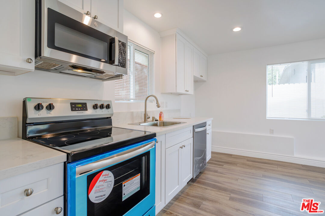 1789 1/2 Atchison Street Pasadena, CA 91104 - Photo 14 of 21 a kitchen with stainless steel appliances a stove a microwave and cabinets